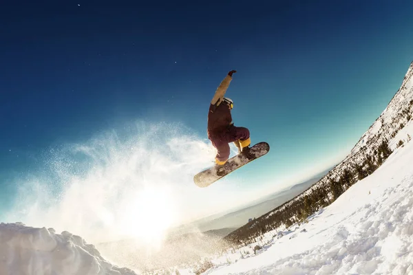 Сноубордист прыгает с трамплина в длину — стоковое фото