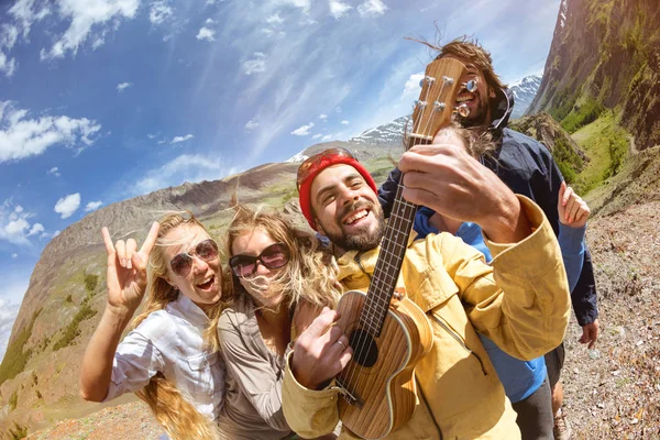 Счастливые друзья весело играют на гитаре на улице — стоковое фото