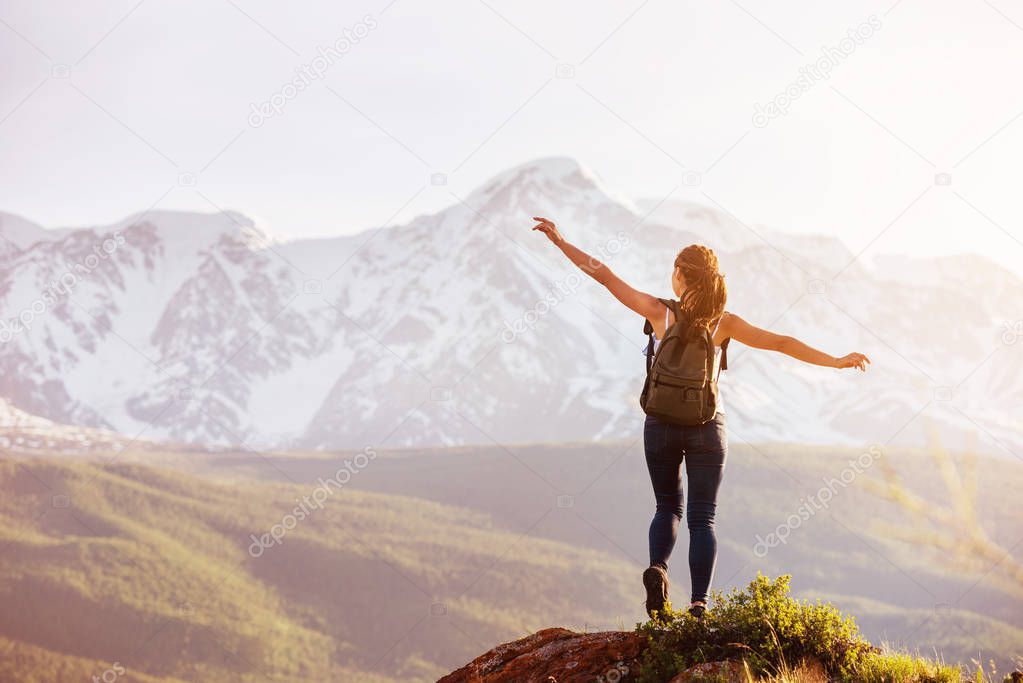 Lady stands big rock against mountains