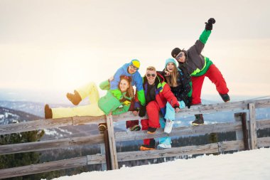 Mutlu arkadaş kayakçı ve Snowboard düşkünleri günbatımı dağlar