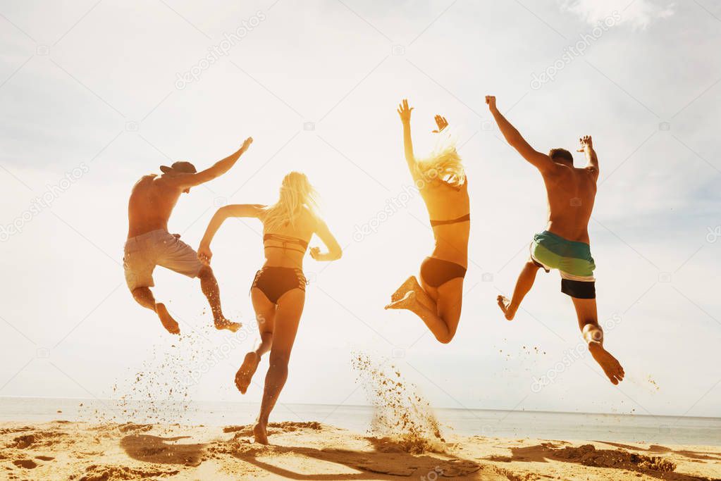 Happy friends sunset beach run jump