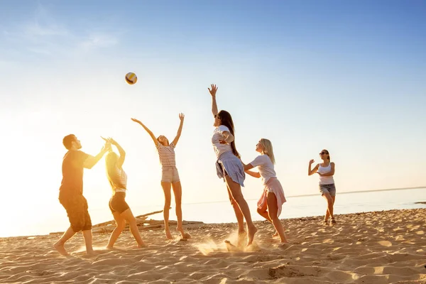 Grupo de amigos juega pelota puesta de sol playa — Foto de Stock