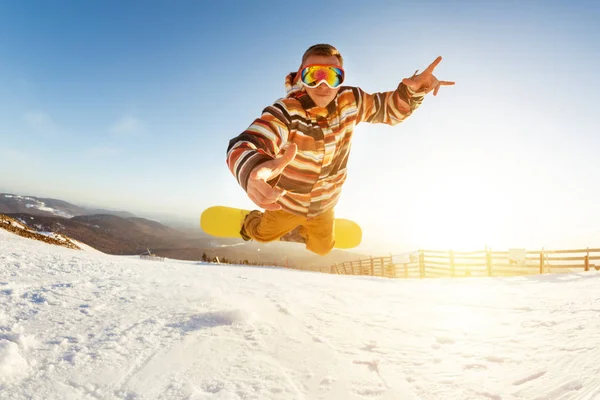 スノーボーダーを持つジャンプの楽しさし 遊び心のあるポーズでゲレンデでドロップ — ストック写真