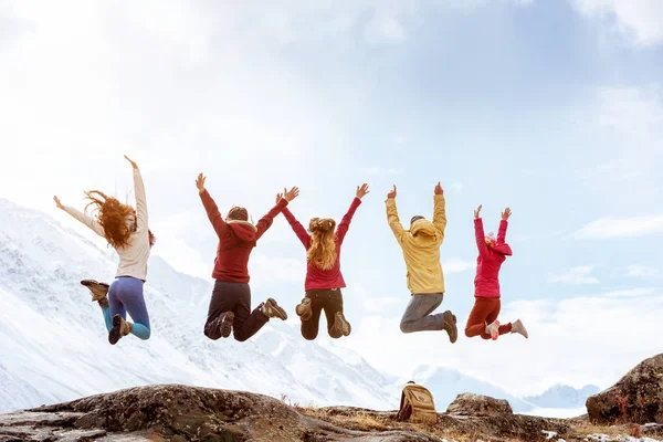 Grupp av glada vänner hoppar mot bergen — Stockfoto