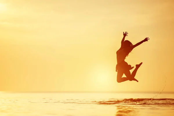 Mulher feliz salta lago pôr do sol de água — Fotografia de Stock