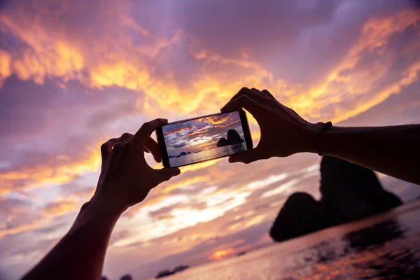 Handen nemen mobiele foto prachtige zonsondergang — Stockfoto