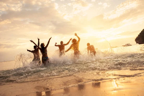 Ευτυχής φίλους στο ηλιοβασίλεμα ειδυλλιακό στη θάλασσα — Φωτογραφία Αρχείου