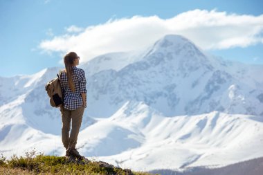 Dağlar, sırt çantası ile kadın duruyor