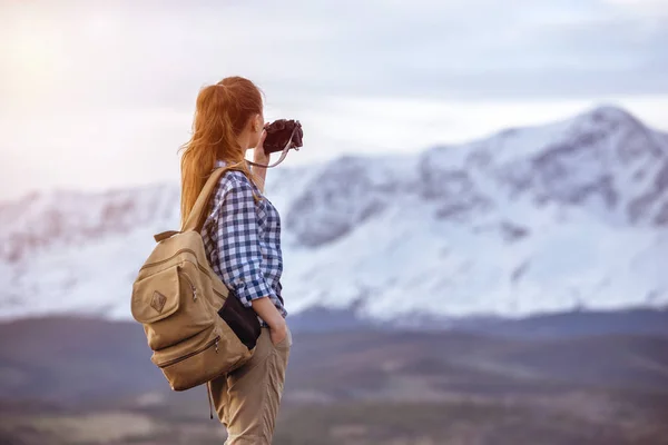 Mujer con mochila tomando fotos de la montaña — Foto de Stock