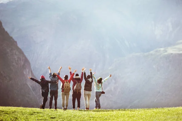 Tevreden wandelaars tegen bergdal met opgeheven armen — Stockfoto