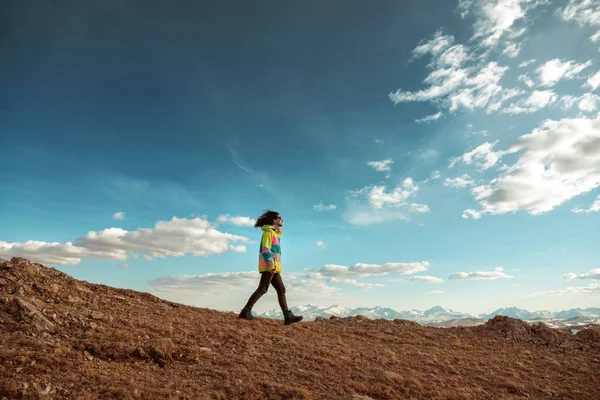 Jedna uśmiechnięta dziewczyna idzie przeciw górach — Zdjęcie stockowe