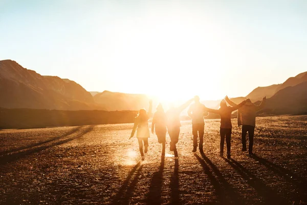 Veel gelukkige vrienden of toeristen loopt naar zonsondergang — Stockfoto