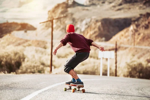 Hipster rider på Long Board av Mountain Road — Stockfoto