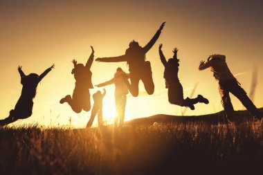 Big group of friends jumps and runs at sunset clipart