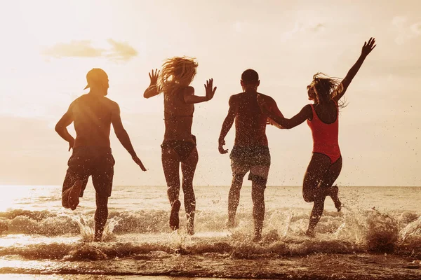Beach party friends runs to the sea — 스톡 사진