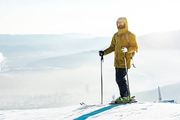 Hombre esquiador se para con esquí en la cima de la montaña — Foto de Stock