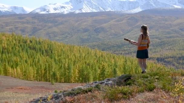 Menina bonita toca guitarra contra montanhas — Vídeo de Stock