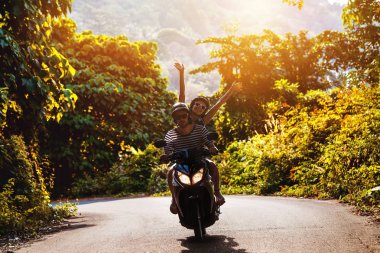 Gün batımı tropik yol karşı scooter mutlu çift