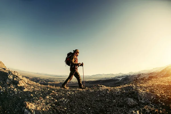 徒步旅行者在日落山中行走 — 图库照片