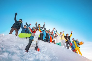 Kayak merkezindeki büyük kayakçılar ve snowboardcular.