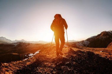İnsan silueti günbatımı dağlarına gider.