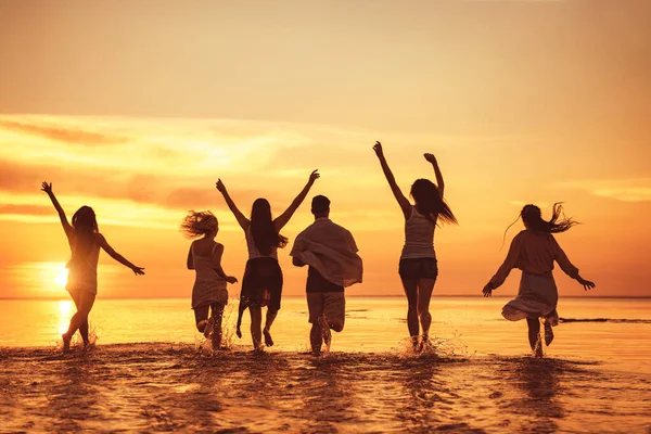 Gran grupo de amigos felices en la fiesta de la playa al atardecer — Foto de Stock