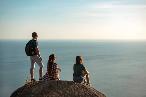 Tre giovani amici gode di mare tramonto — Foto Stock