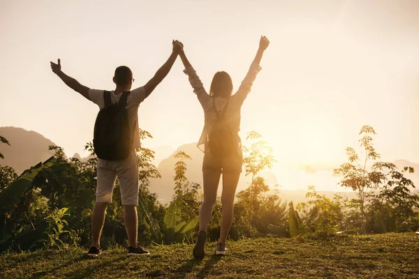 Két boldog turista felemelt karokkal napkeltekor. — Stock Fotó