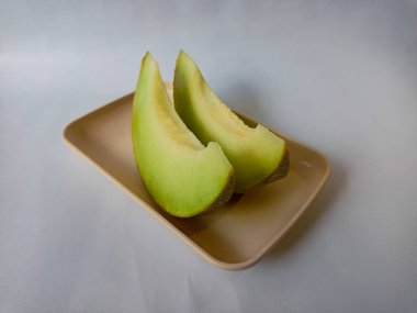 Beyaz arka planda doğranmış taze yeşil kavun meyvesi..