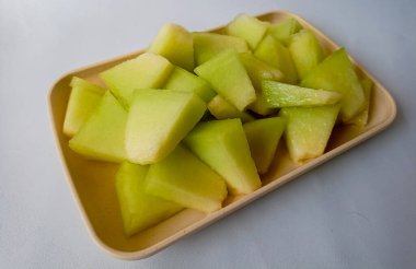 Beyaz arka planda doğranmış taze yeşil kavun meyvesi..