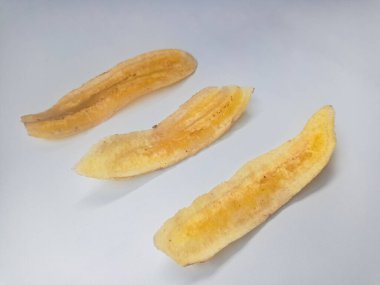 Beyaz arka planda izole edilmiş taze muz cipsi yığını.