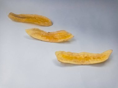 Beyaz arka planda izole edilmiş taze muz cipsi yığını.