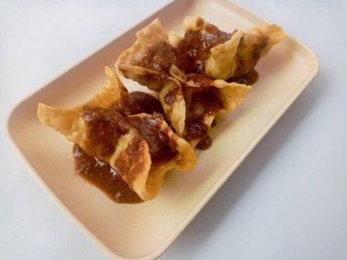 Beyaz arka planda izole edilmiş Batagor, balık ya da tavuk köftesi, tofu, tapyoka unu ve fıstık sosuyla servis ediliyor. Endonezya yemekleri.