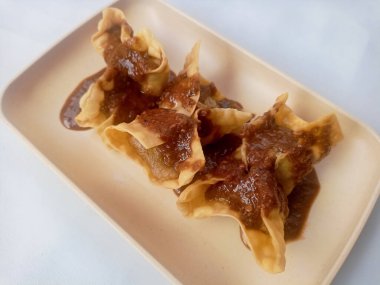 Beyaz arka planda izole edilmiş Batagor, balık ya da tavuk köftesi, tofu, tapyoka unu ve fıstık sosuyla servis ediliyor. Endonezya yemekleri.