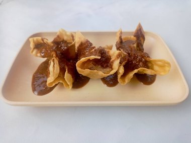 Beyaz arka planda izole edilmiş Batagor, balık ya da tavuk köftesi, tofu, tapyoka unu ve fıstık sosuyla servis ediliyor. Endonezya yemekleri.