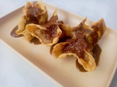 Beyaz arka planda izole edilmiş Batagor, balık ya da tavuk köftesi, tofu, tapyoka unu ve fıstık sosuyla servis ediliyor. Endonezya yemekleri.