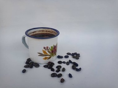 Beyaz arka planda kahve fincanı ve kahve çekirdeği.