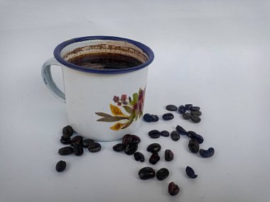 Beyaz arka planda kahve fincanı ve kahve çekirdeği.