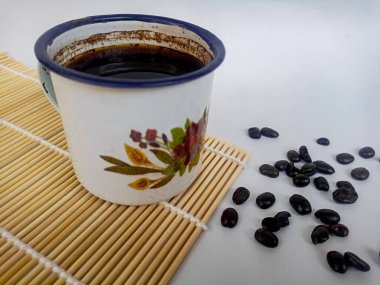 Beyaz arka planda kahve fincanı ve kahve çekirdeği.