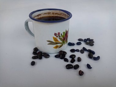 Beyaz arka planda kahve fincanı ve kahve çekirdeği.