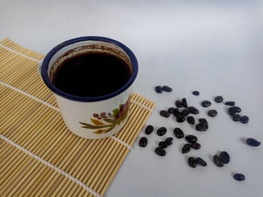 Beyaz arka planda kahve fincanı ve kahve çekirdeği.