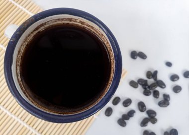 Beyaz arka planda kahve fincanı ve kahve çekirdeği.