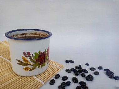 Beyaz arka planda kahve fincanı ve kahve çekirdeği.