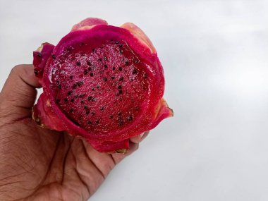 Elde ejderha meyvesi arka planda kırmızı, taze, organik, tropik, tatlı, pitaya sağlıklı kaktüs pitahaya besin olgunlaşmış çiğ, parlak Asya meyveleri.