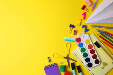 Renkli okul malzemeleri hafif bir arka planda okul sezonu için güzelce düzenlenmiş.