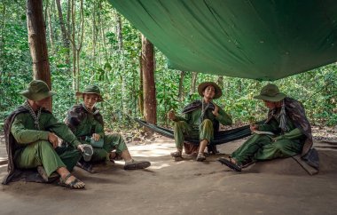 Askerler bir gölgelik altında oturuyor. Ku Chi tünellerinin yakınına Amerikan Vietnam savaşının kurulması. 15 Kasım 2017. Ho Chi Minh City, Vietnam