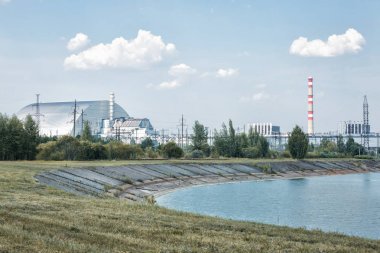 Soğutma havuzunun kıyısından Çernobil Npp'nin dördüncü güç ünitesine görünüm
