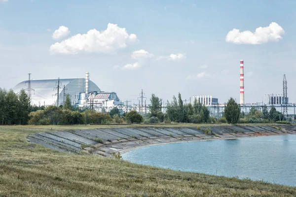 Soğutma havuzunun kıyısından Çernobil Npp'nin dördüncü güç ünitesine görünüm