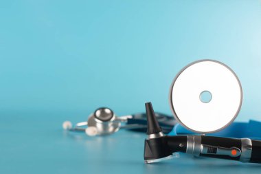 Mavi backgroun üzerinde stetoskop ve reflektör ayna ile Otoskop