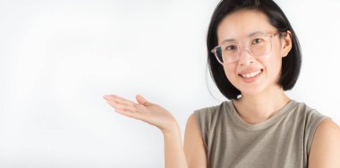 Kısa siyah saçlı, beyaz dişli ve büyük gözlüklü sevimli bir Asyalı kadın mutlu bir şekilde gülümsüyor. Beyaz arka planda yüz ifadelerini ve gözlerini ifade eden ve uzayı kopyalayan başarılı olmaktan mutluyum.